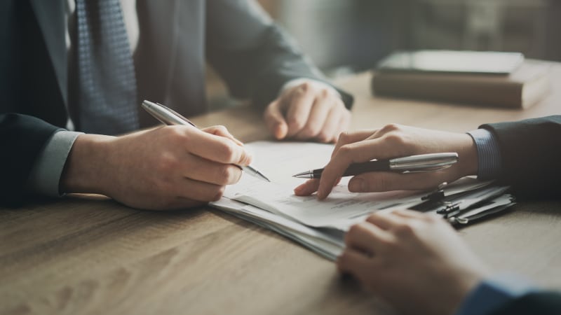 Commercial re-financing documentation being reviewed, representing the detailed legal work involved in re-financing commercial property